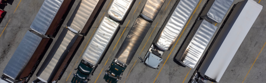 several semi trucks in parking lot aerial view