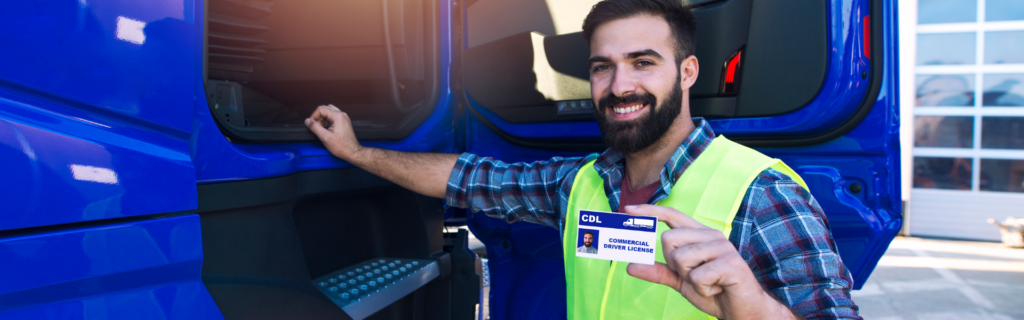 man standing next to blue semi truck holding CDL