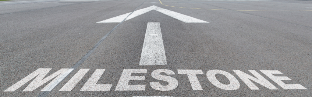 road painted with the word milestone and an arrow