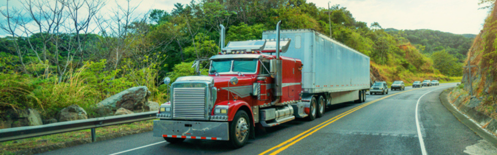 semi truck on mountain road with cars behind
