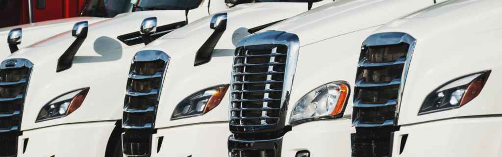 line of new white semi trucks parked