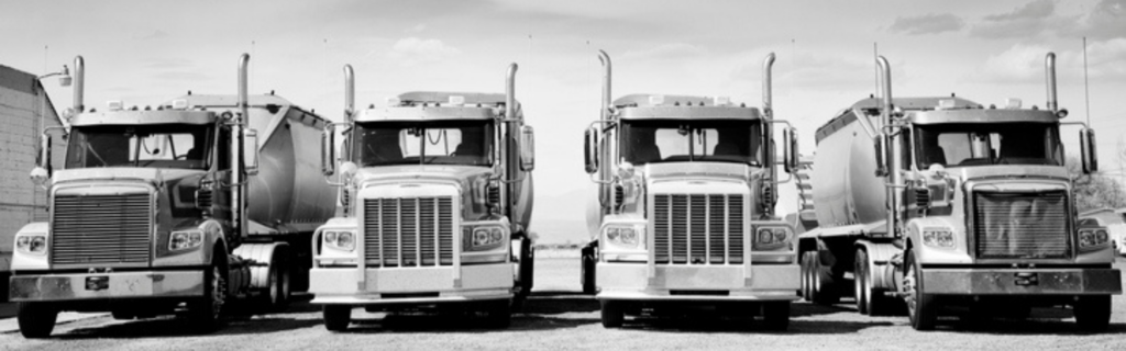 black and white photo of vintage semi trucks