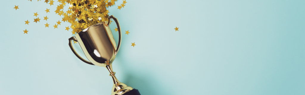 confetti stars spilling out of gold trophy on light blue background
