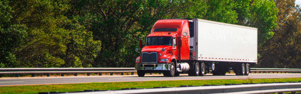 red semi truck driving on road