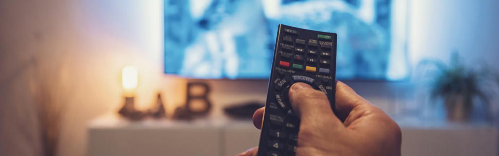 man holding remote with tv in background
