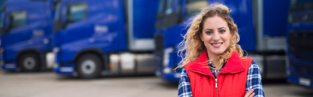 woman standing in front of parked semi trucks