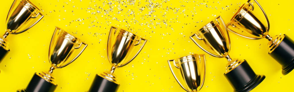 trophies and confetti on yellow background