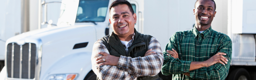 two men standing in front of semi truck