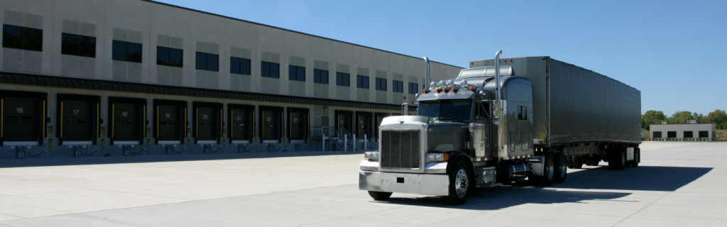 semi truck parked behind commercial loading dock area
