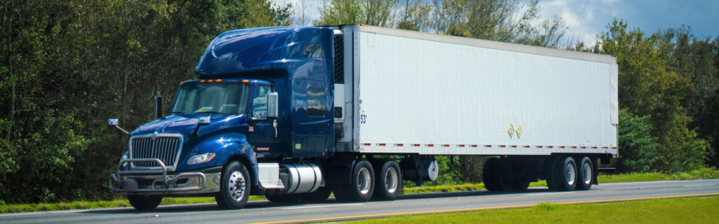 blue semi truck pulling white trailer