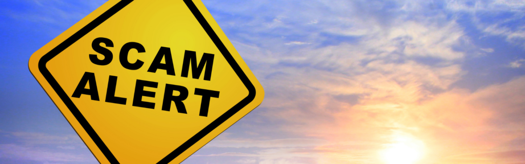 yellow road sign that reads "scam alert"