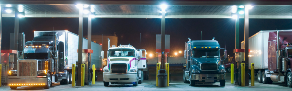 semi trucks parked under canopy at fuel island truck stop